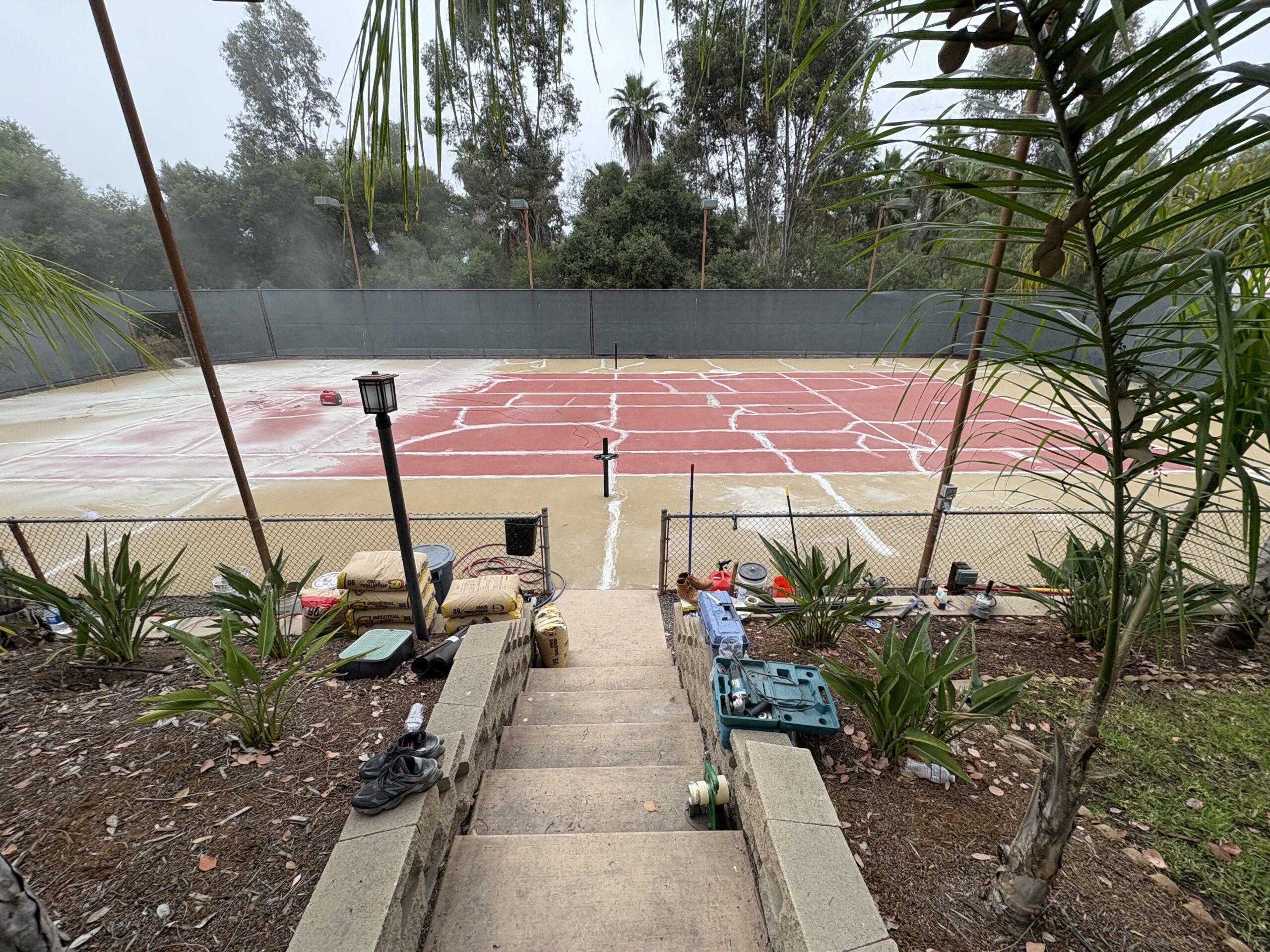Backyard tennis court before, cracked surface
